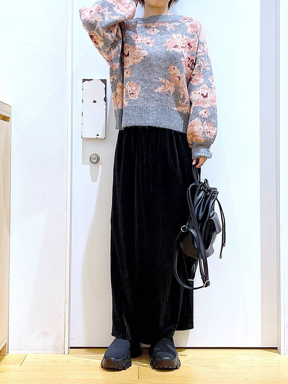 ブラック系のバックパック/リュック、ブラック系のスカート、ブラック系のブーツを着用したレディースの秋コーディネートの6枚目の写真