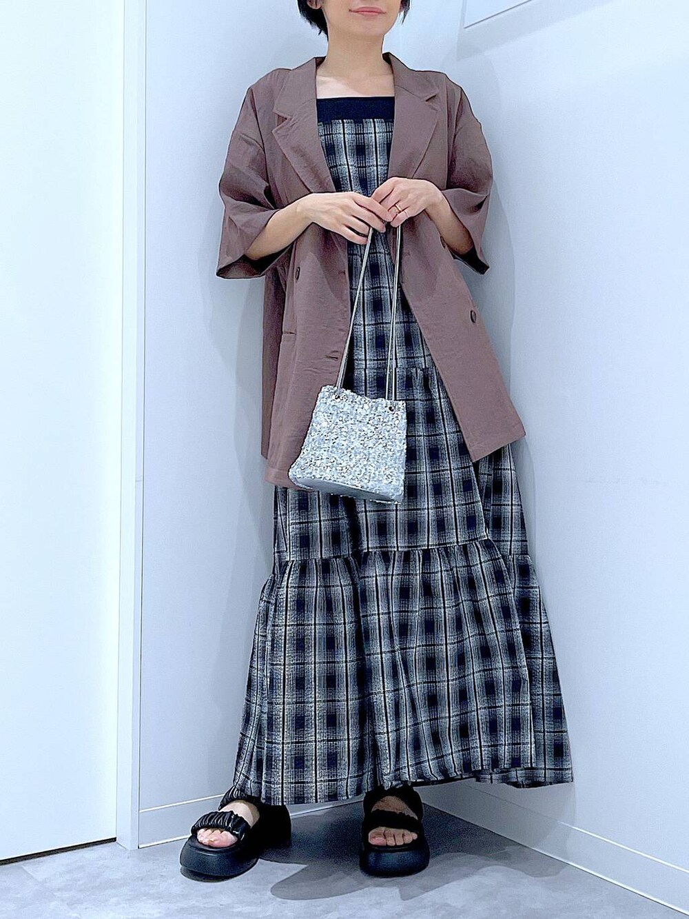 ブラック系のサンダル、シルバー系のショルダーバッグ、ブラウン系のテーラードジャケットを着用したレディースの夏コーディネートの6枚目の写真