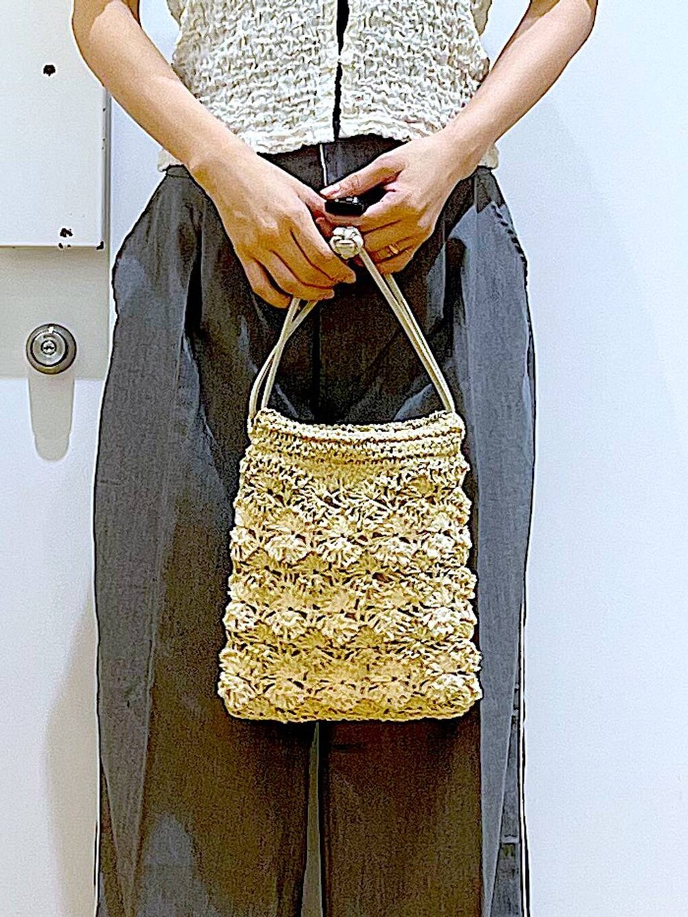 ホワイト系のサンダル、ベージュ系のショルダーバッグ、ホワイト系のカーディガン/ボレロを着用したレディースの夏コーディネートの9枚目の写真