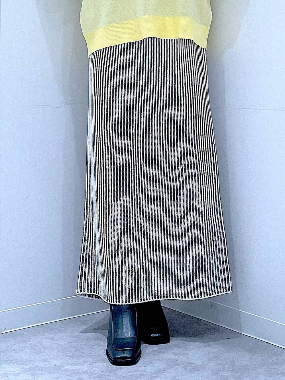 ホワイト系のショルダーバッグ、ベージュ系のスカート、ブラック系のブーツを着用したレディースの冬コーディネートの8枚目の写真