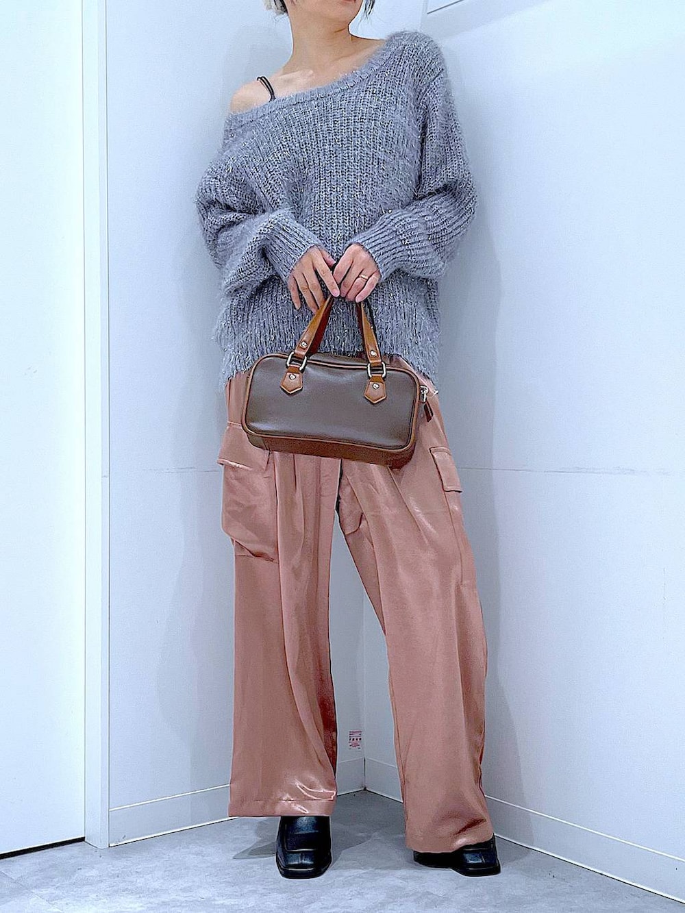 ブラック系のブーツ、ブラウン系のショルダーバッグ、ピンク系のカーゴパンツを着用したレディースの冬コーディネートの6枚目の写真