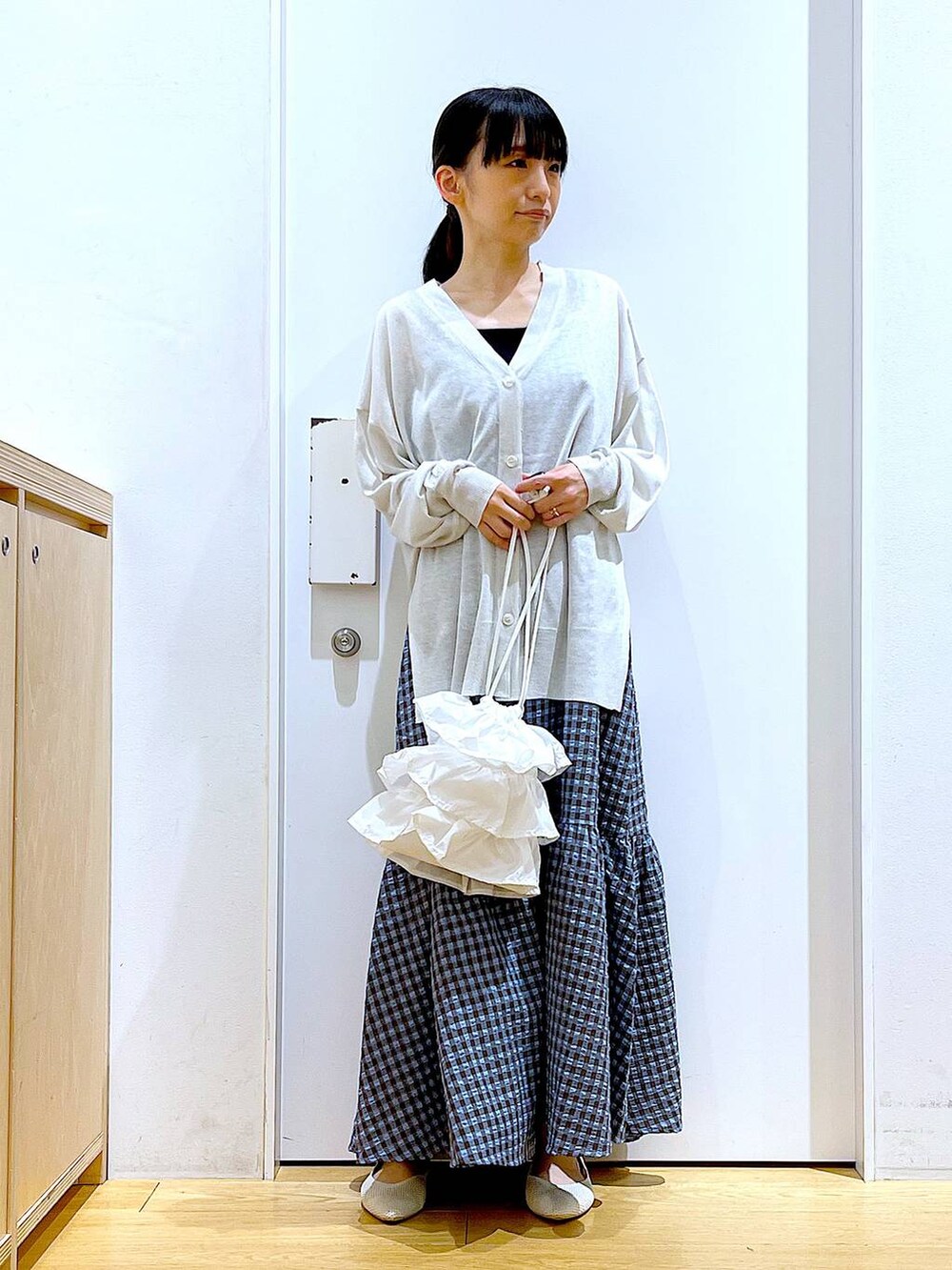 ホワイト系のショルダーバッグ、ブルー系のワンピース、ホワイト系のパンプスを着用したレディースの春コーディネートの2枚目の写真