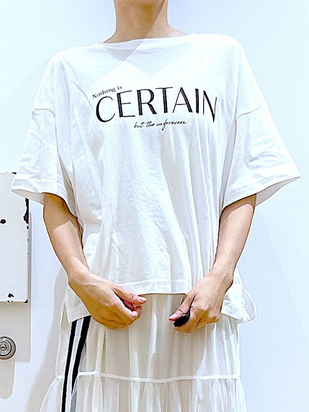 ホワイト系のサンダル、ホワイト系のスカート、ホワイト系のTシャツ/カットソーを着用したレディースの夏コーディネートの7枚目の写真