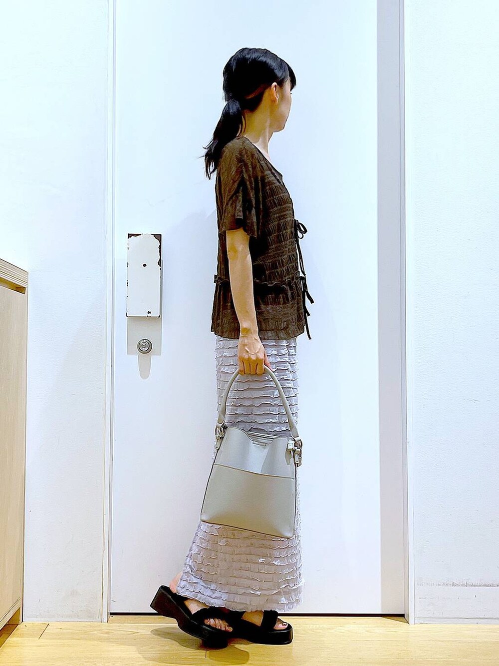 ブラック系のサンダル、グレー系のショルダーバッグ、グレー系のスカートを着用したレディースの秋コーディネートの4枚目の写真