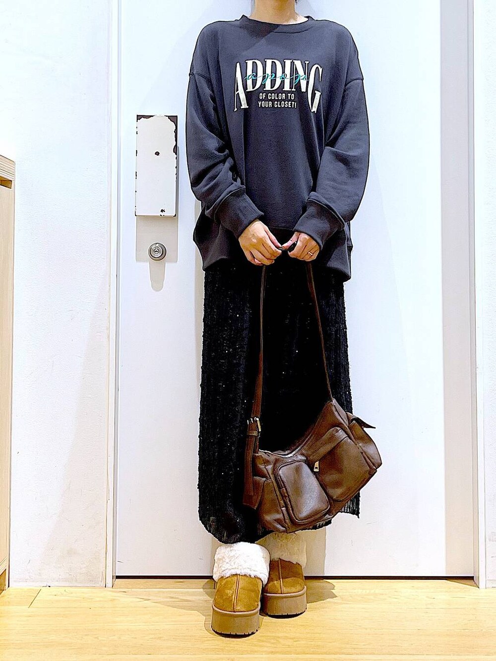 ベージュ系のスリッポン、ブラック系のスカート、グレー系のスウェットを着用したレディースの秋コーディネートの6枚目の写真