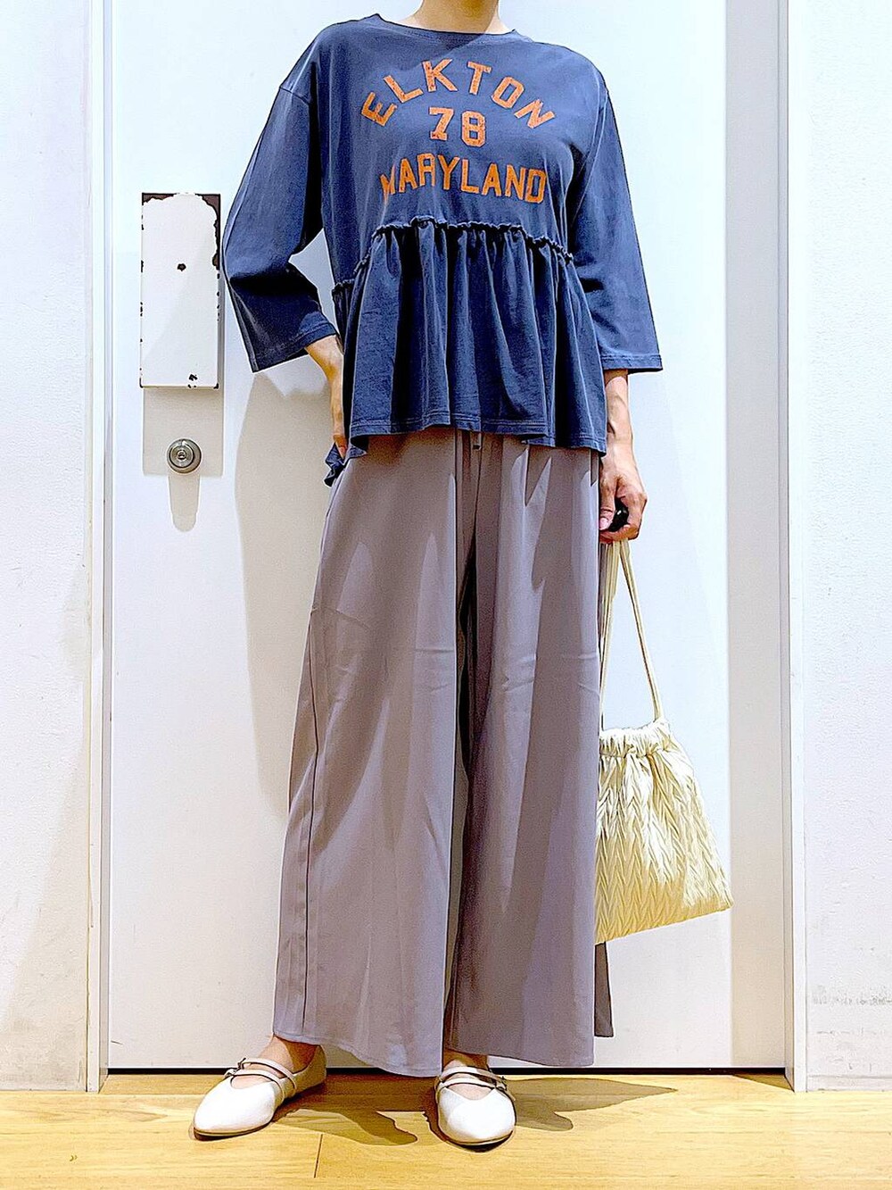 ホワイト系のショルダーバッグ、グレー系のその他パンツ、ホワイト系のパンプスを着用したレディースの秋コーディネートの6枚目の写真