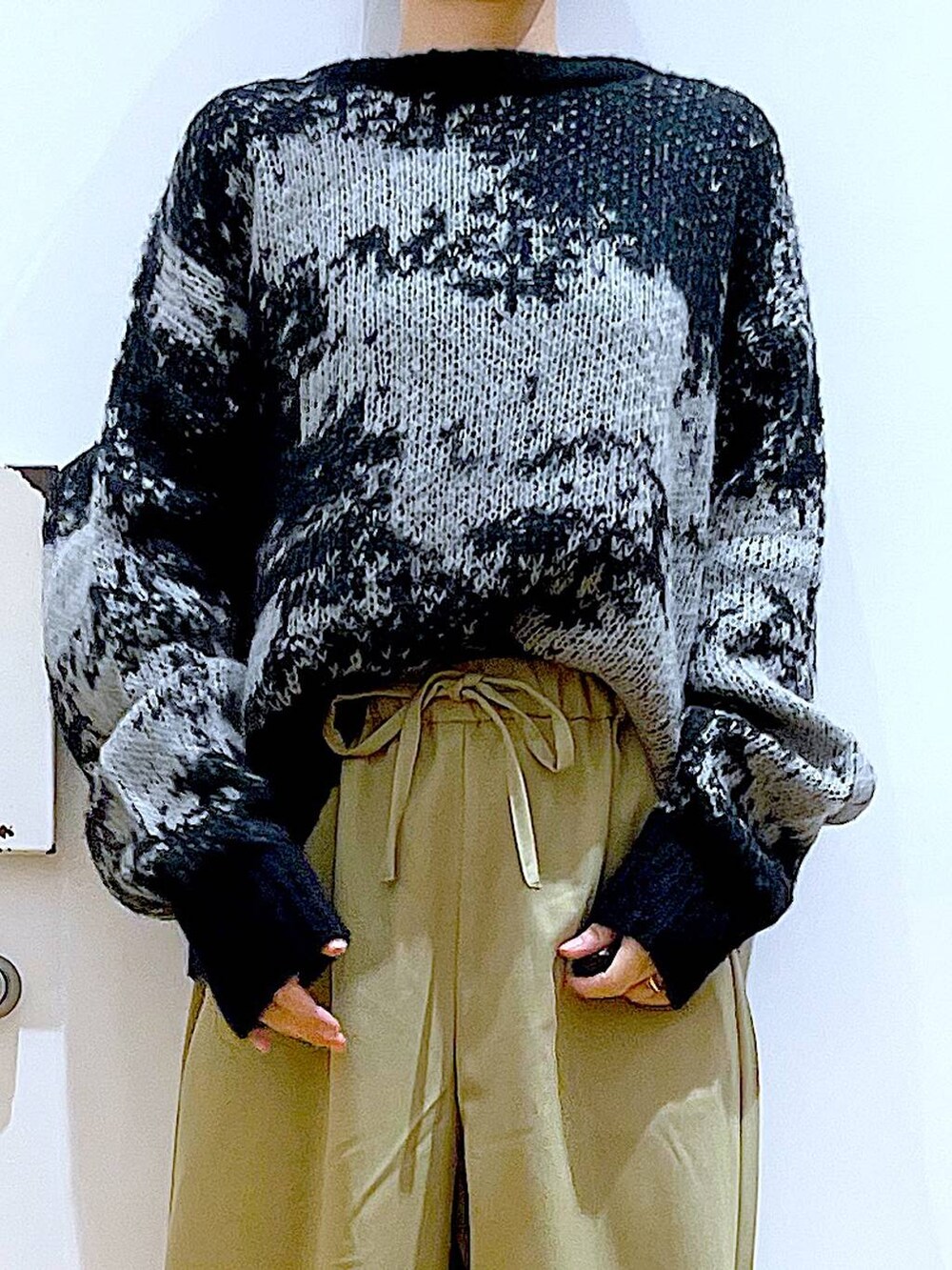 ブラック系のショルダーバッグ、ブラック系のブーツ、イエロー系のその他パンツを着用したレディースの冬コーディネートの7枚目の写真