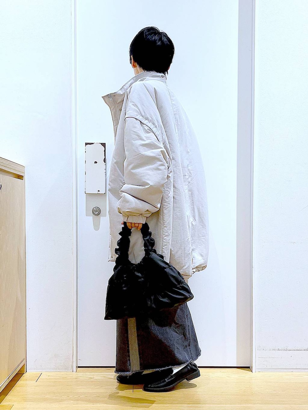 ブラック系のローファー、グレー系のその他アウター、ブラック系のショルダーバッグを着用したレディースの冬コーディネートの3枚目の写真