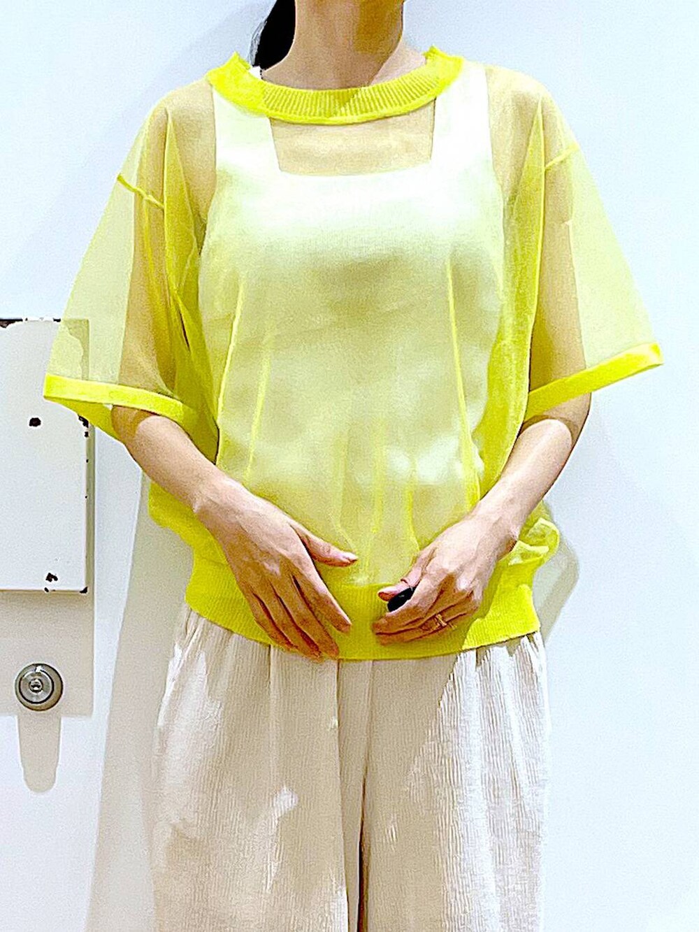 イエロー系のニット/セーター、ホワイト系のその他パンツ、ホワイト系のニット/セーターを着用したレディースの夏コーディネートの7枚目の写真