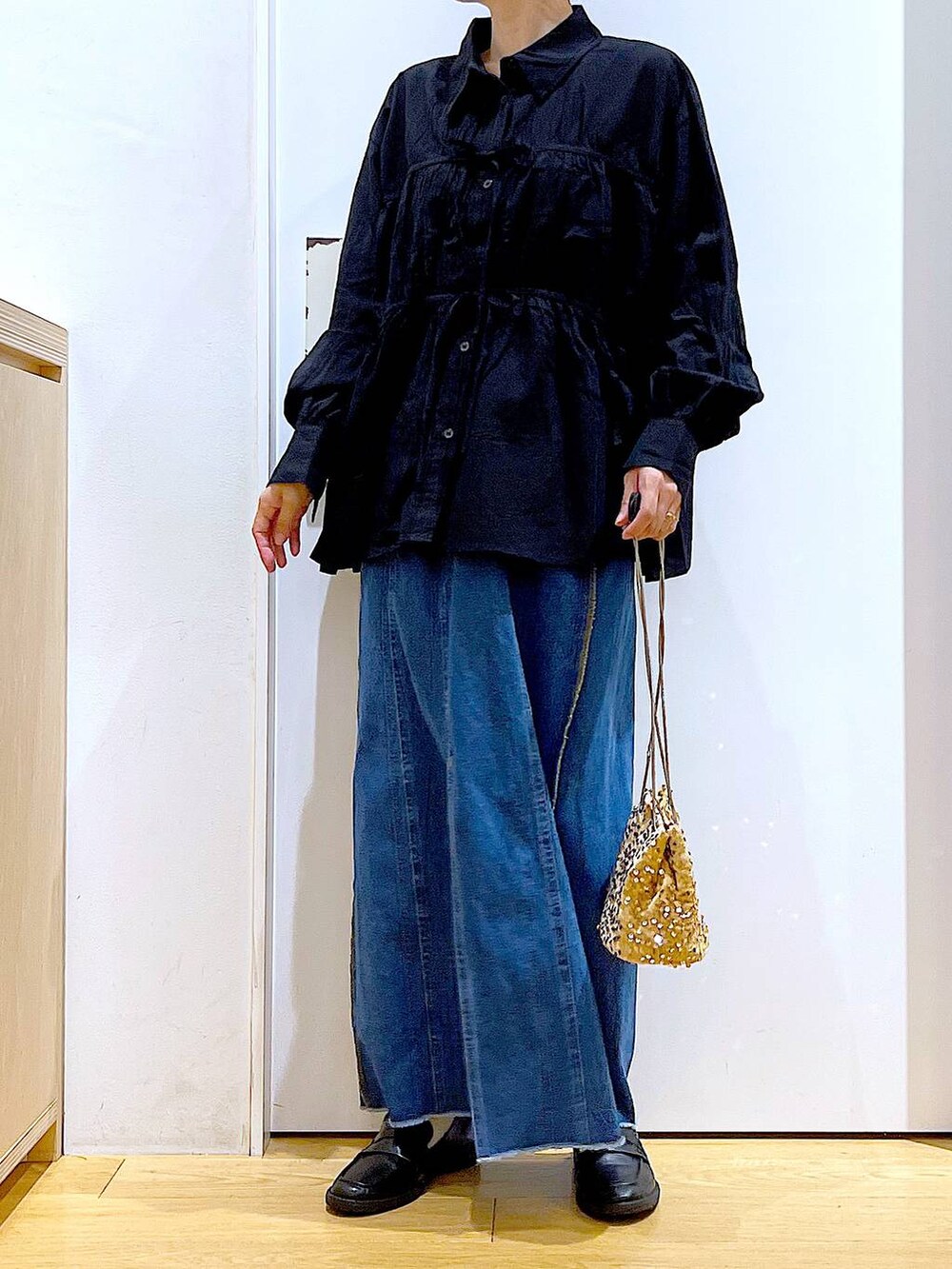 ベージュ系のショルダーバッグ、ブラック系のローファー、ブラック系のシャツ/ブラウスを着用したレディースの秋コーディネートの6枚目の写真