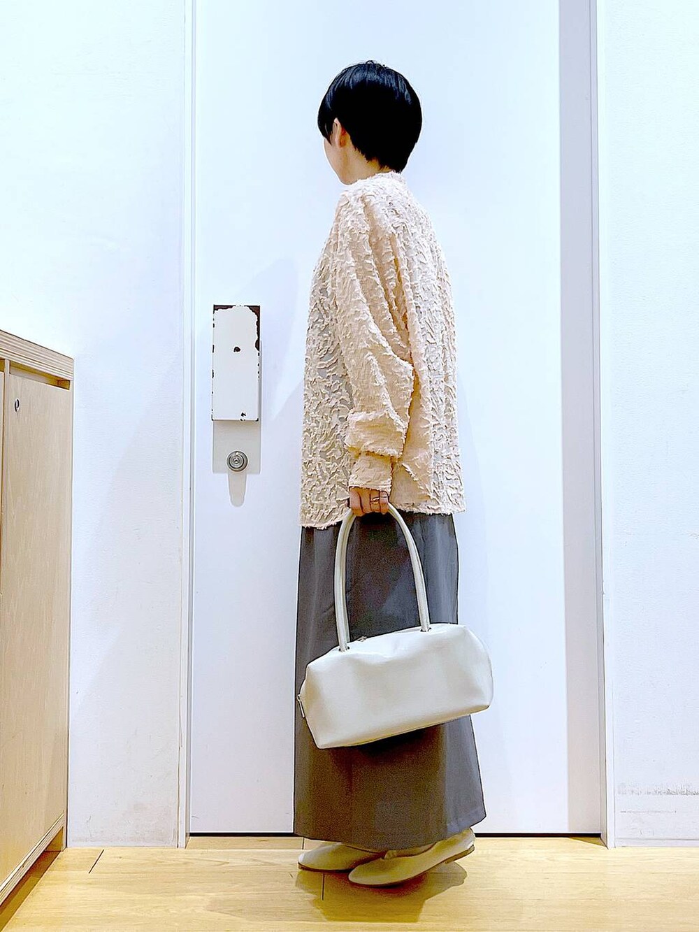 ホワイト系のボストンバッグ、ホワイト系のパンプス、ピンク系のシャツ/ブラウスを着用したレディースの春コーディネートの3枚目の写真