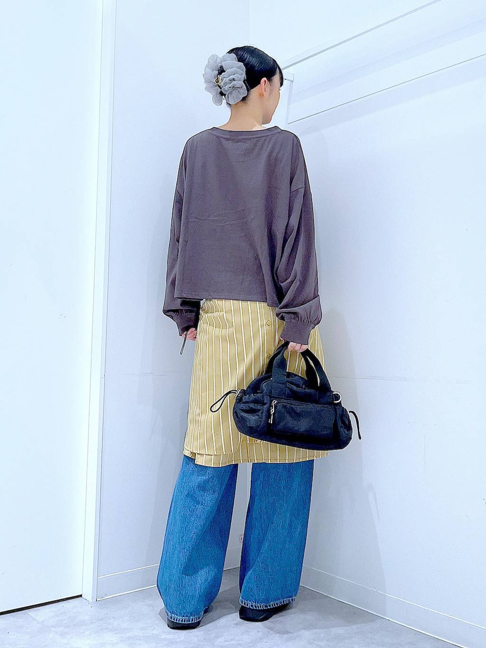 ブルー系のデニムパンツ、イエロー系のシャツ/ブラウス、グレー系のTシャツ/カットソーを着用したレディースの秋コーディネートの5枚目の写真