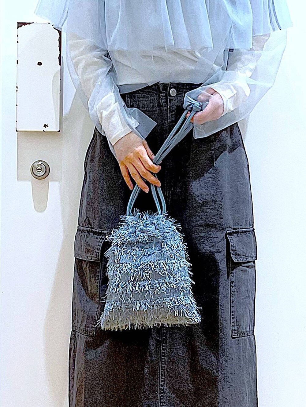 グレー系のデニムスカート、ブラック系のスニーカー、ブルー系のその他トップスを着用したレディースの春コーディネートの9枚目の写真