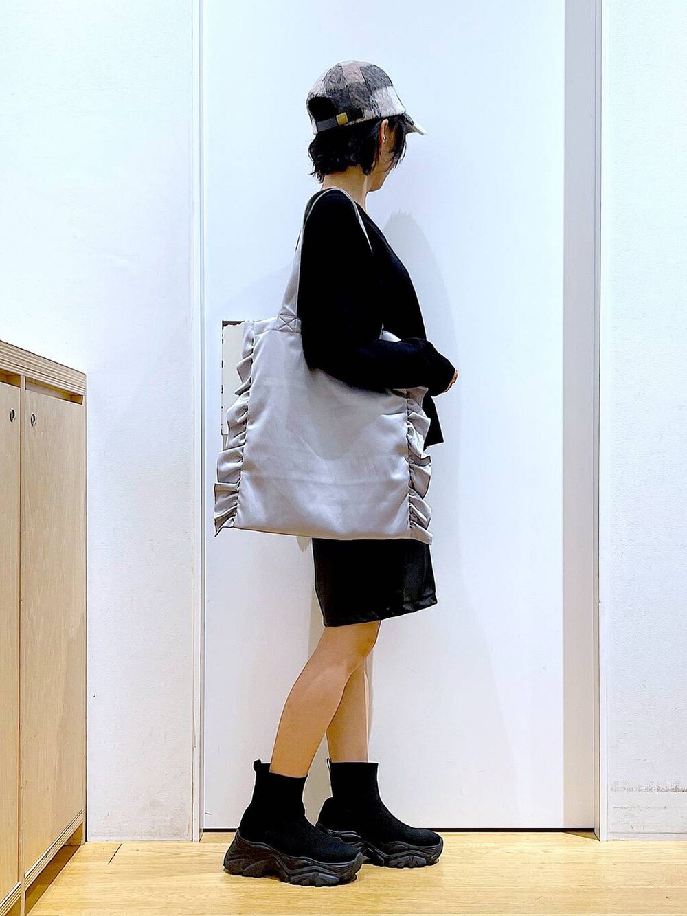 ブラック系のブーツ、グレー系のトートバッグ、ブラック系のその他パンツを着用したレディースの秋コーディネートの4枚目の写真