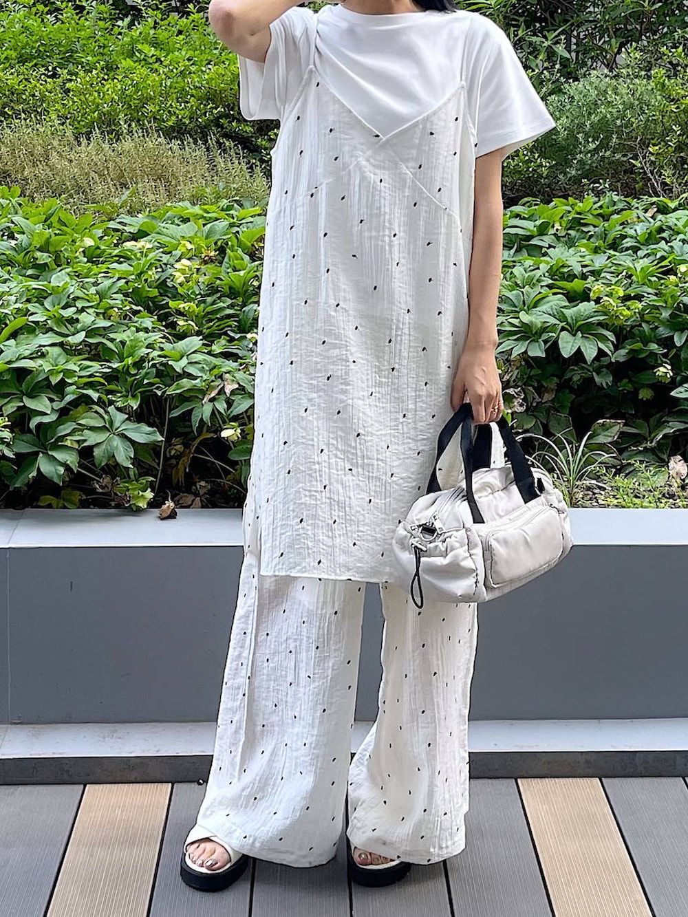 ホワイト系のサンダル、ホワイト系のTシャツ/カットソー、ホワイト系のショルダーバッグを着用したレディースの夏コーディネートの6枚目の写真