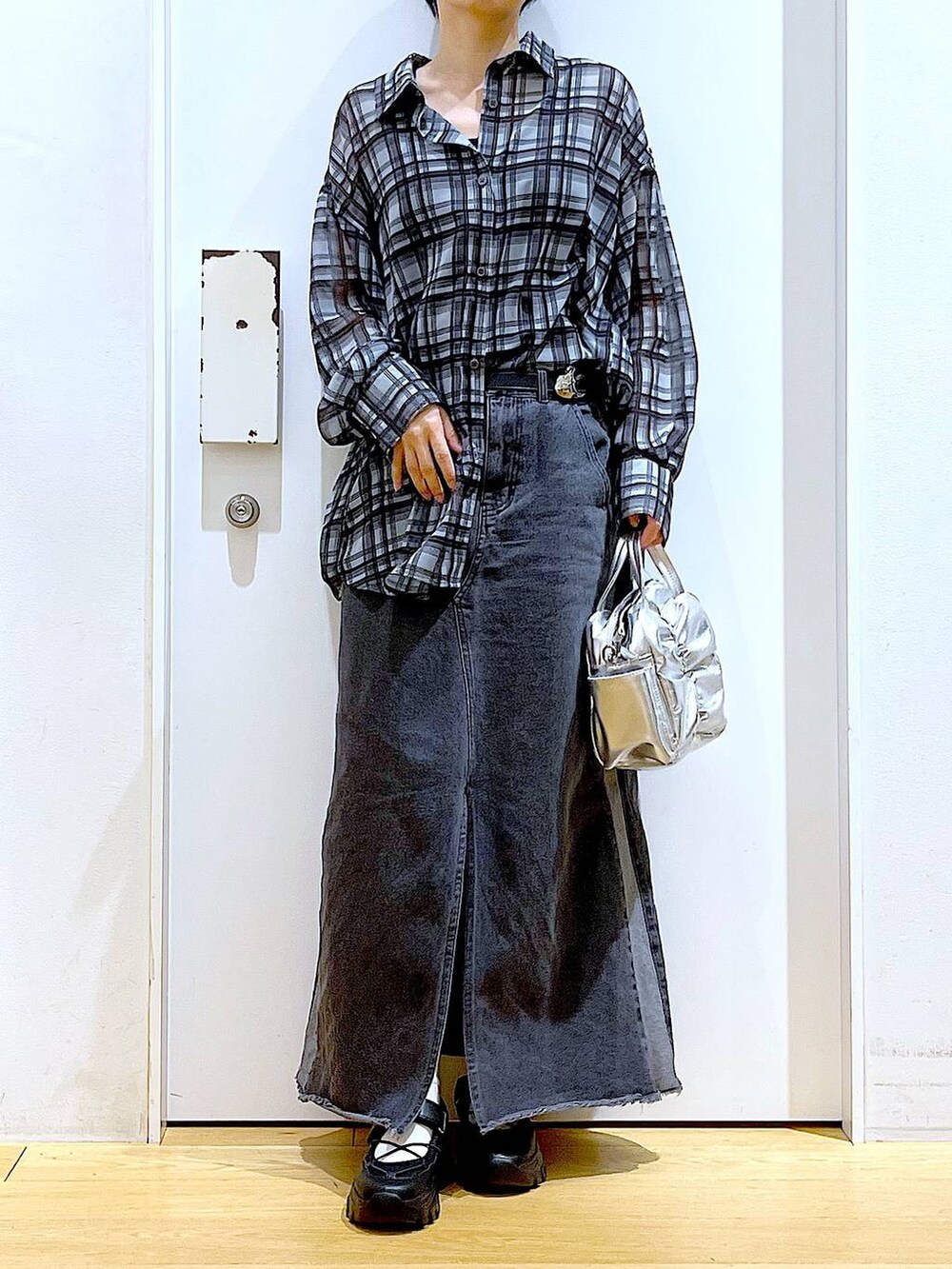 ブラック系のスニーカー、ブラック系のデニムスカート、グレー系のシャツ/ブラウスを着用したレディースの春コーディネートの6枚目の写真