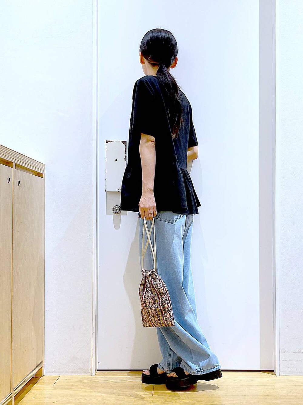 ピンク系のショルダーバッグ、ブルー系のデニムパンツ、ブラック系のTシャツ/カットソーを着用したレディースの夏コーディネートの3枚目の写真