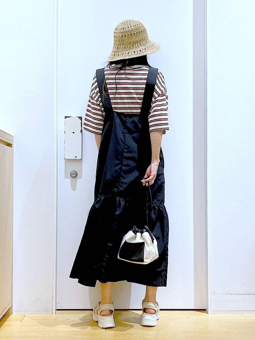 ホワイト系のショルダーバッグ、ブラック系のワンピース、ベージュ系のサンダルを着用したレディースの春コーディネートの5枚目の写真