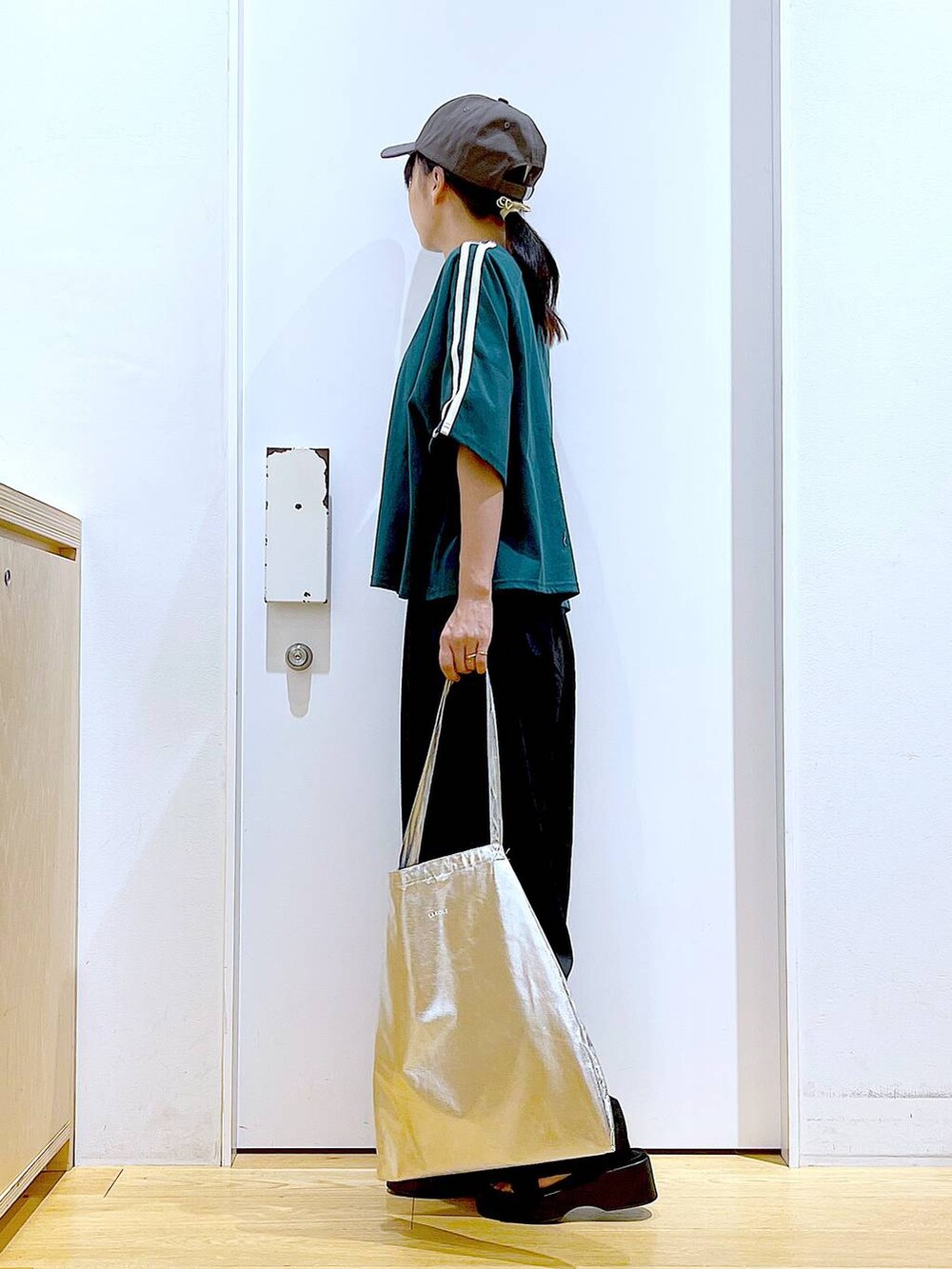 シルバー系のトートバッグ、ブラック系のサンダル、ブラック系のその他パンツを着用したレディースの夏コーディネートの3枚目の写真