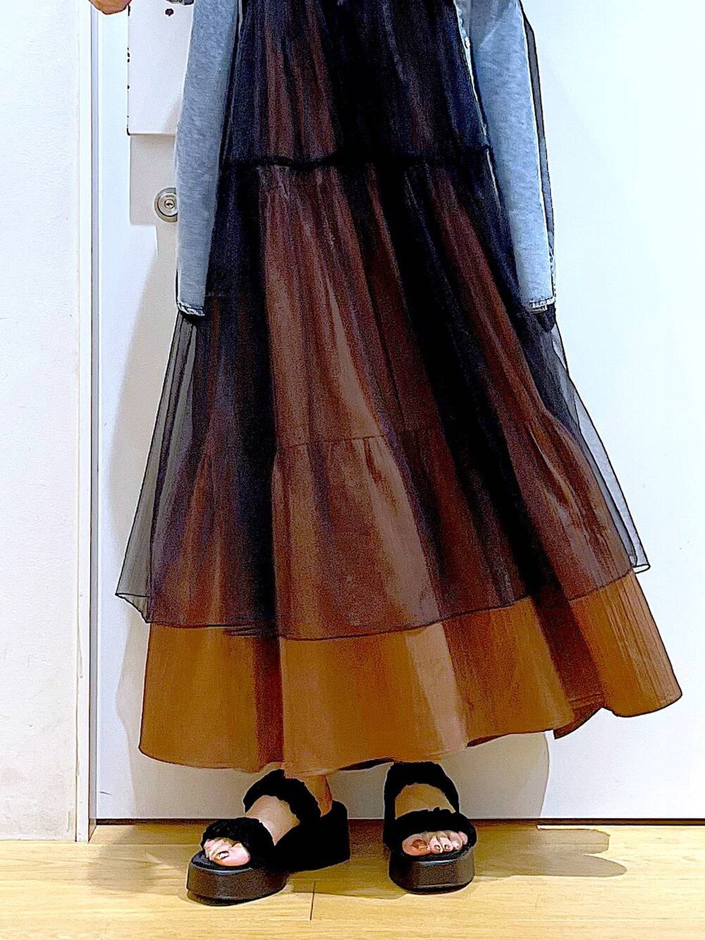 ブラック系のサンダル、ブラウン系のトートバッグ、ブラック系のワンピースを着用したレディースの夏コーディネートの8枚目の写真