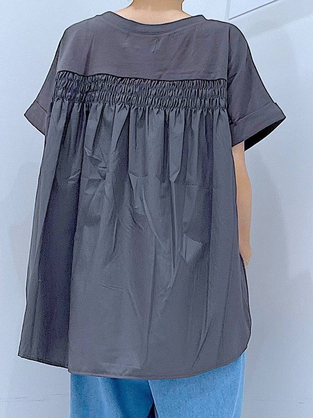 ブラック系のショルダーバッグ、ブラック系のサンダル、ブルー系のデニムパンツを着用したレディースの夏コーディネートの7枚目の写真