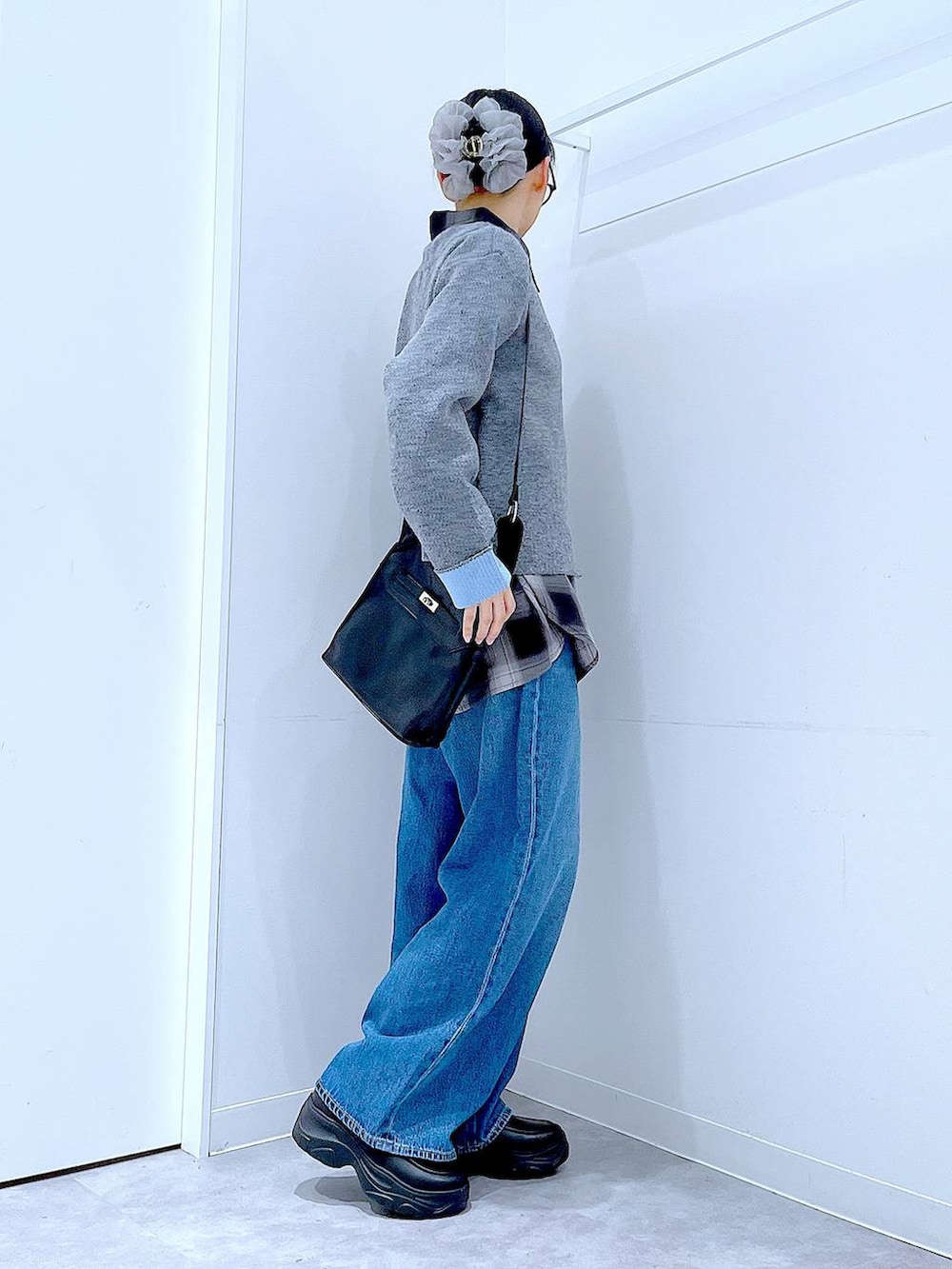 ブルー系のデニムパンツ、ブラック系のシャツ/ブラウス、ブラック系のショルダーバッグを着用したレディースの秋コーディネートの4枚目の写真