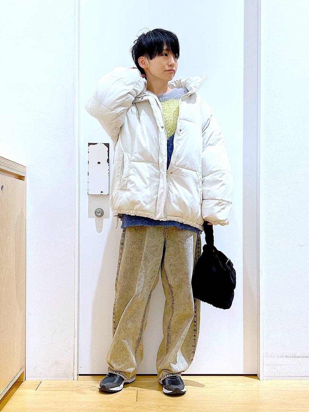 ベージュ系のブルゾン、ブラック系のショルダーバッグ、ベージュ系のデニムパンツを着用したレディースの冬コーディネートの2枚目の写真