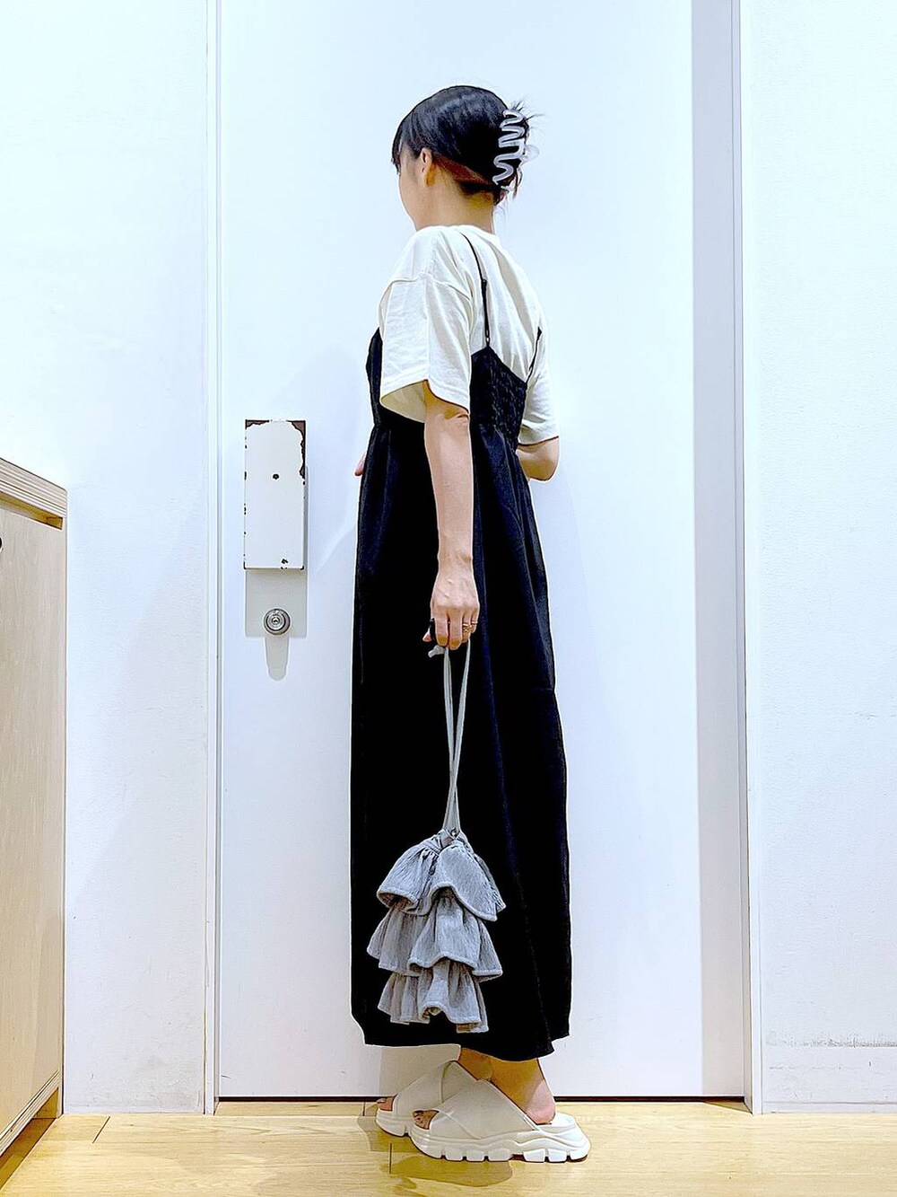 ホワイト系のサンダル、ベージュ系のTシャツ/カットソー、ブラック系のワンピースを着用したレディースの夏コーディネートの3枚目の写真