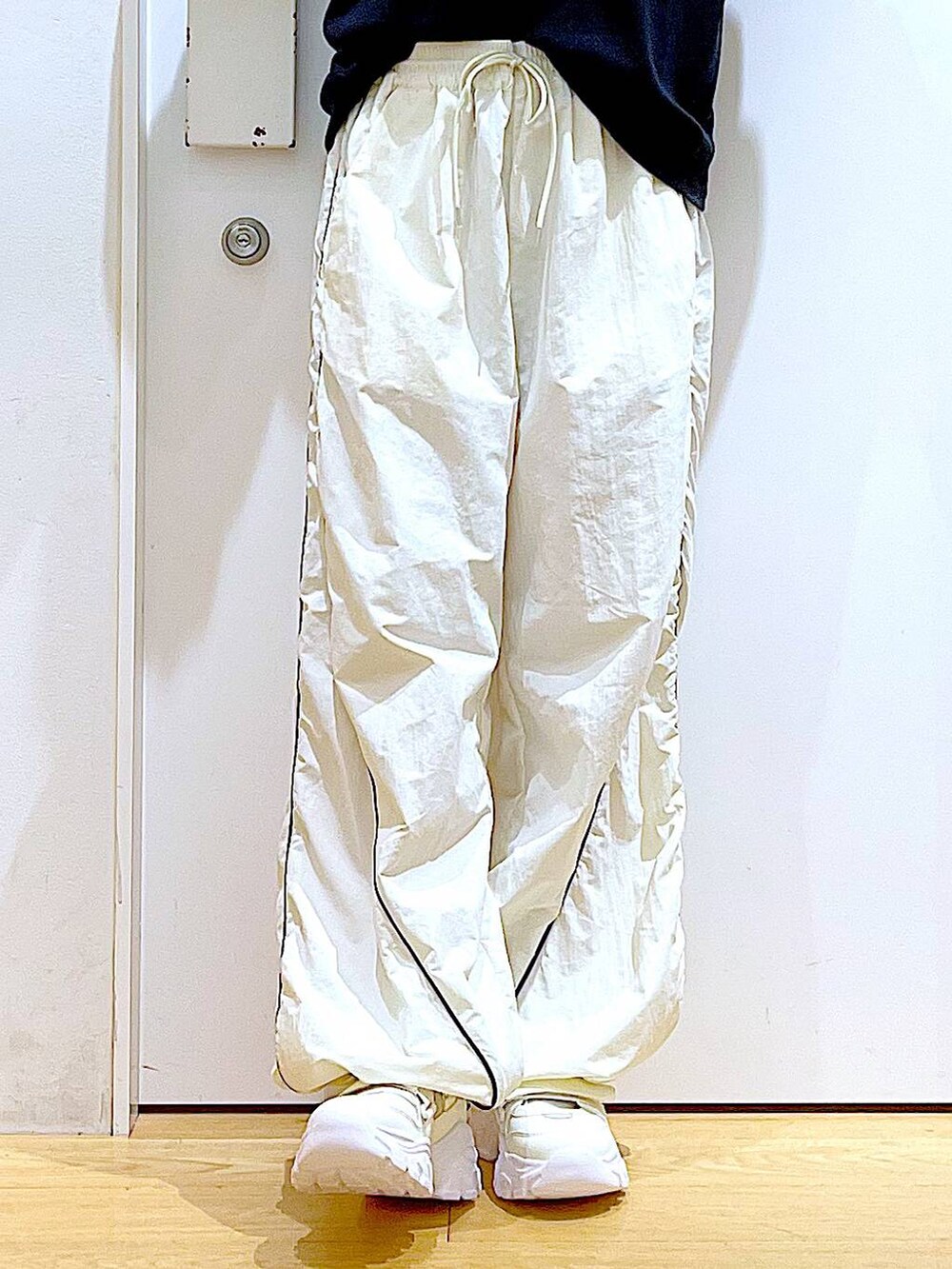 ホワイト系のスニーカー、ベージュ系のその他パンツ、ブラック系のトートバッグを着用したレディースの秋コーディネートの8枚目の写真