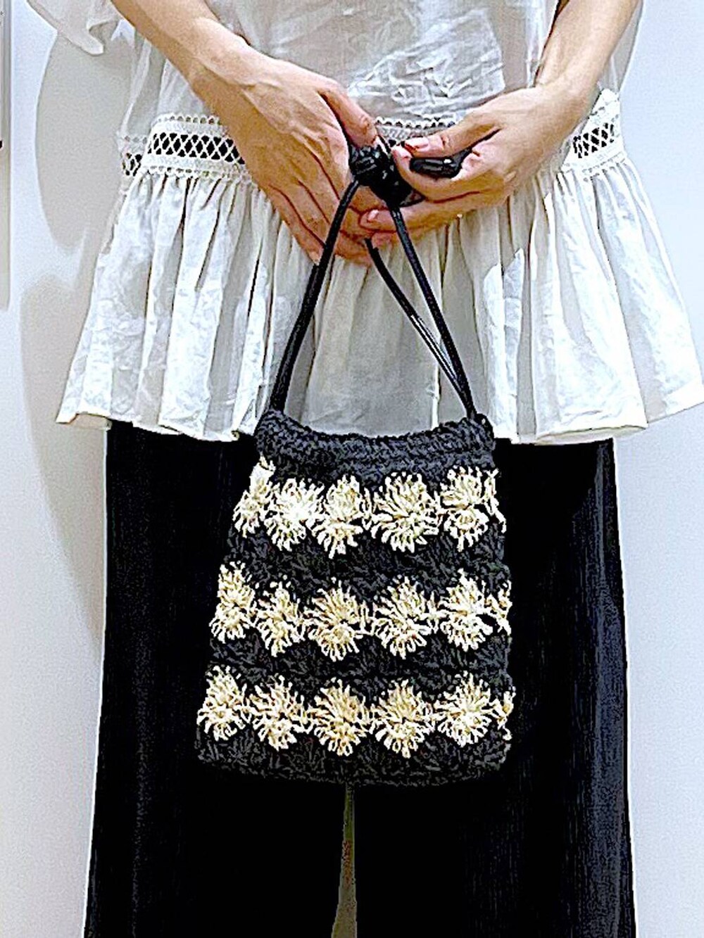 ホワイト系のチュニック、ブラック系のその他パンツ、ブラック系のパンプスを着用したレディースの夏コーディネートの9枚目の写真