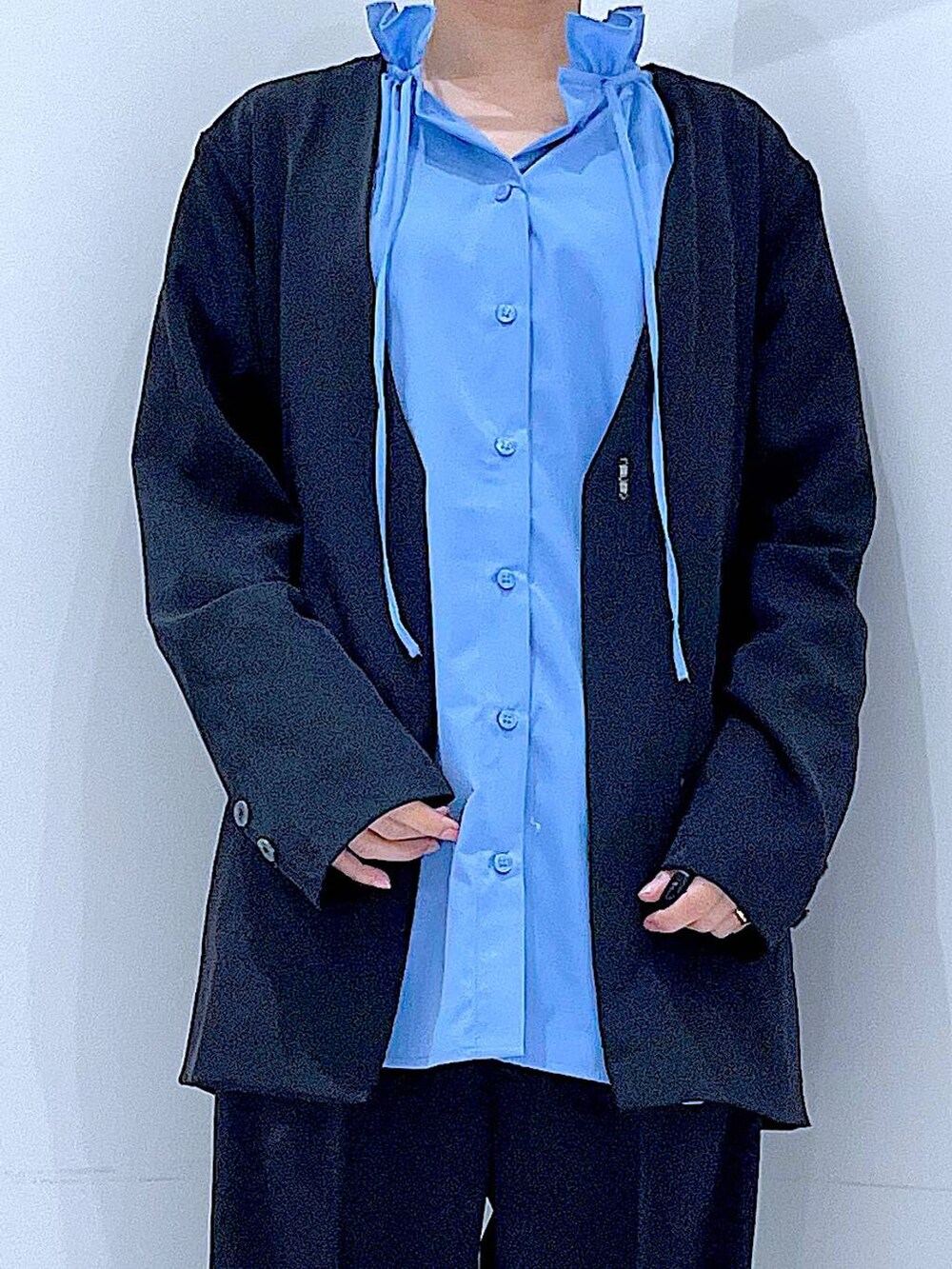 ブラック系のブーツ、ブラック系のトートバッグ、ブラック系のノーカラージャケットを着用したレディースの冬コーディネートの7枚目の写真