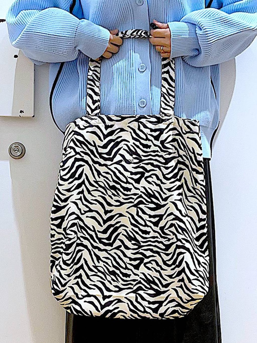 グレー系のTシャツ/カットソー、ブラック系のブーツ、その他のトートバッグを着用したレディースの春コーディネートの9枚目の写真