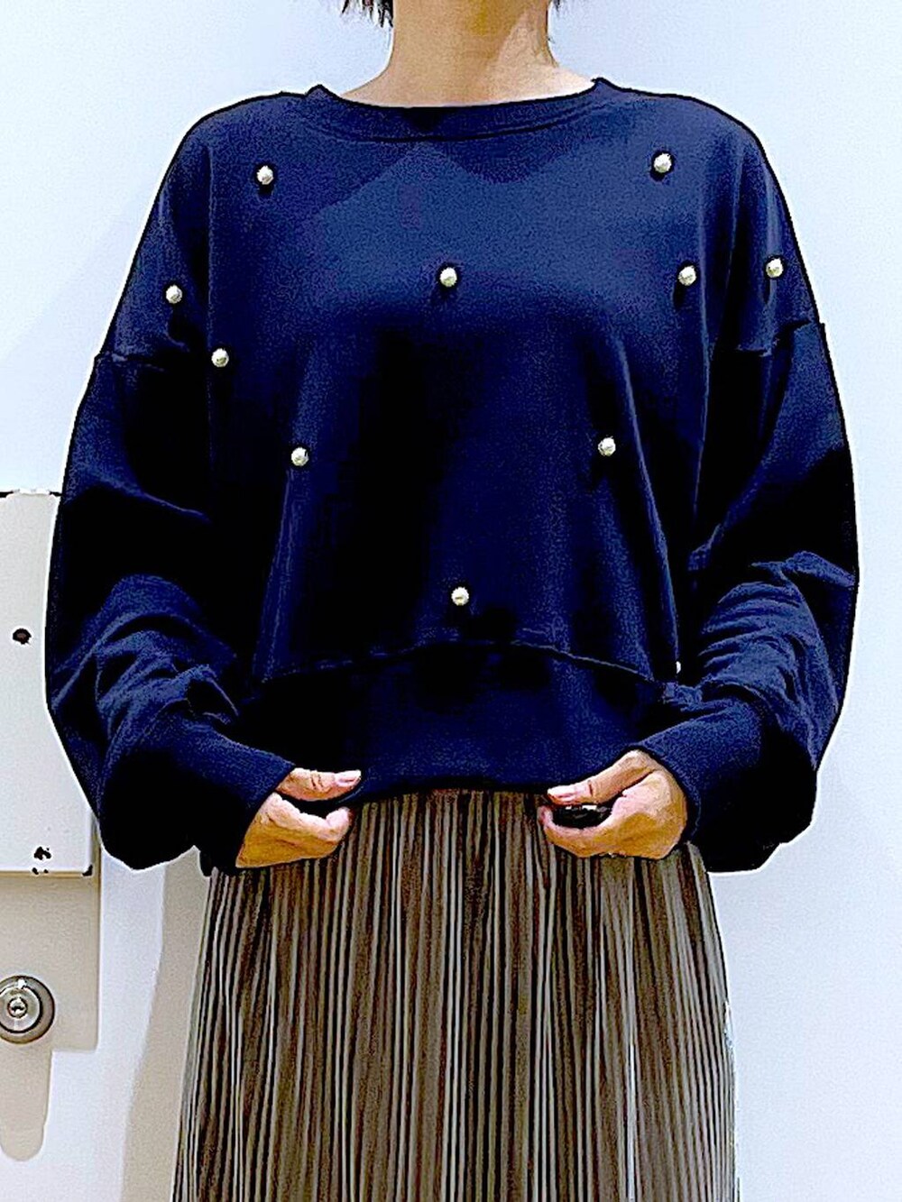 ホワイト系のハンドバッグ、ブラック系のブーツ、ブルー系のスウェットを着用したレディースの秋コーディネートの7枚目の写真