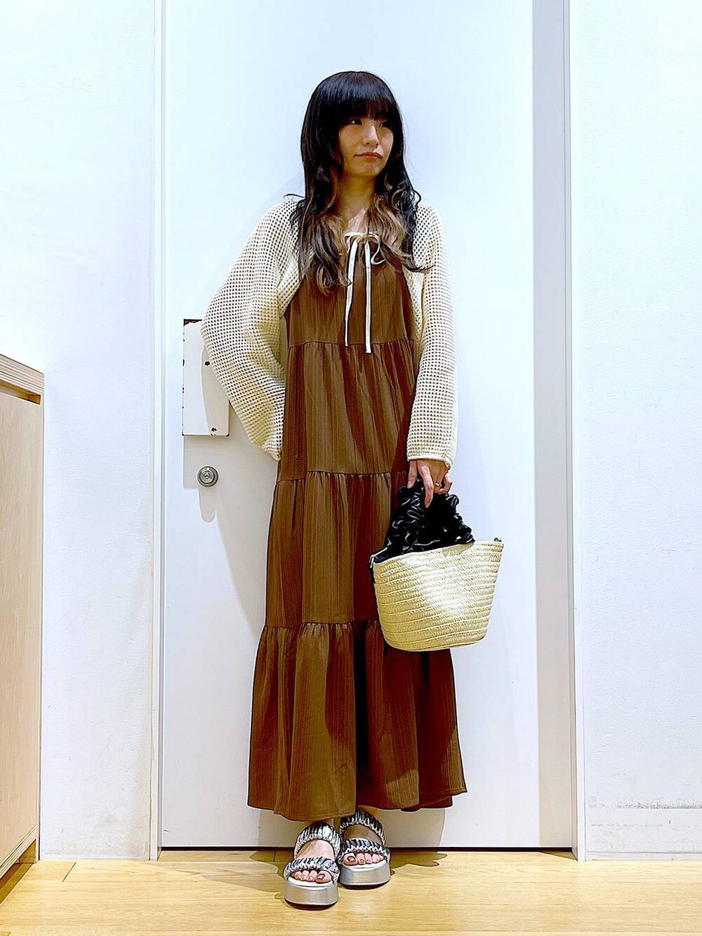 シルバー系のサンダル、ホワイト系のショルダーバッグ、ホワイト系のカーディガン/ボレロを着用したレディースの夏コーディネートの2枚目の写真