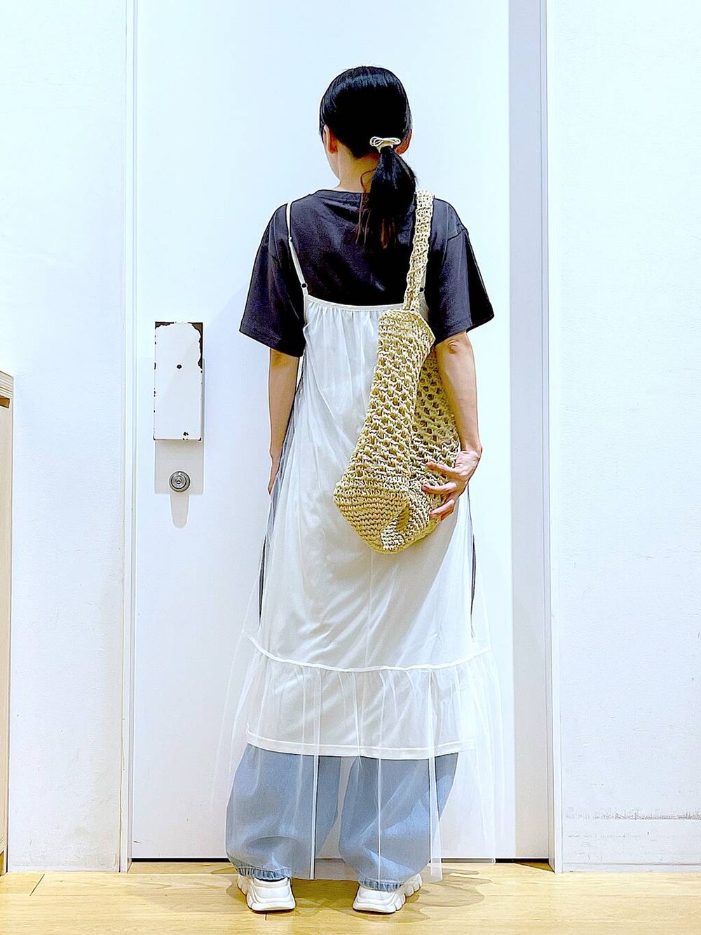 ホワイト系のサンダル、ブルー系のデニムパンツ、ホワイト系のトートバッグを着用したレディースの夏コーディネートの5枚目の写真