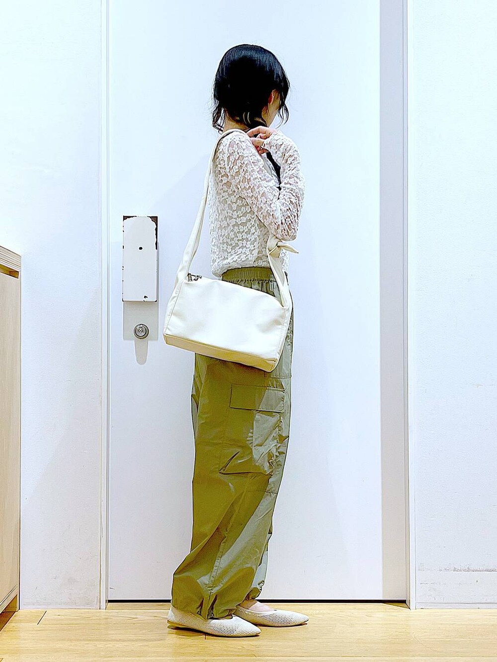 グリーン系のカーゴパンツ、ホワイト系のショルダーバッグ、ホワイト系のパンプスを着用したレディースの春コーディネートの4枚目の写真