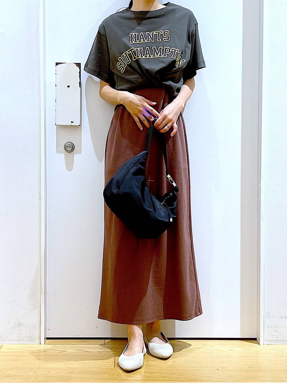 レッド系のワンピース、ブラック系のショルダーバッグ、ホワイト系のパンプスを着用したレディースの春コーディネートの6枚目の写真