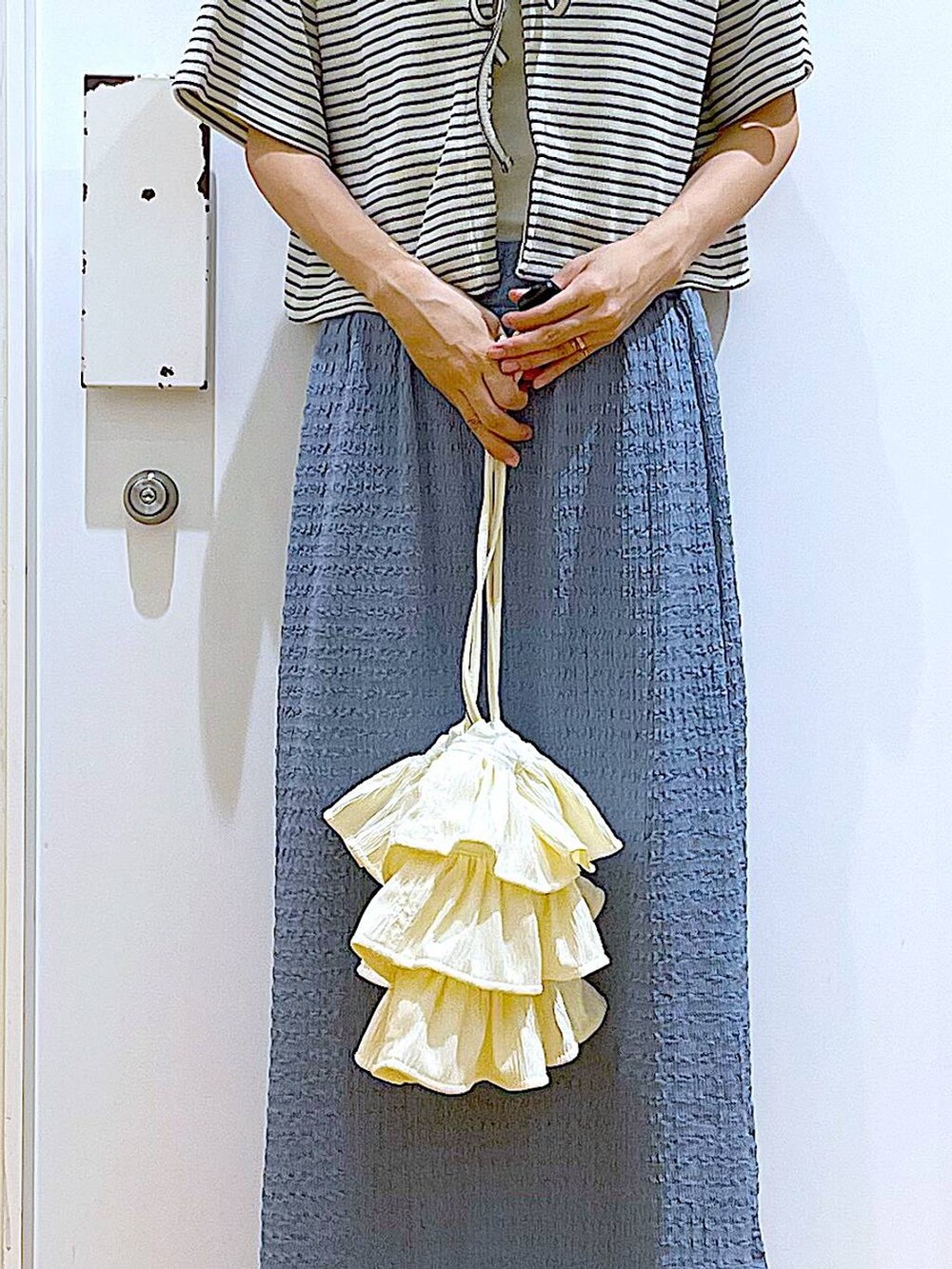 ホワイト系のサンダル、ブルー系のスカート、ホワイト系のショルダーバッグを着用したレディースの秋コーディネートの9枚目の写真