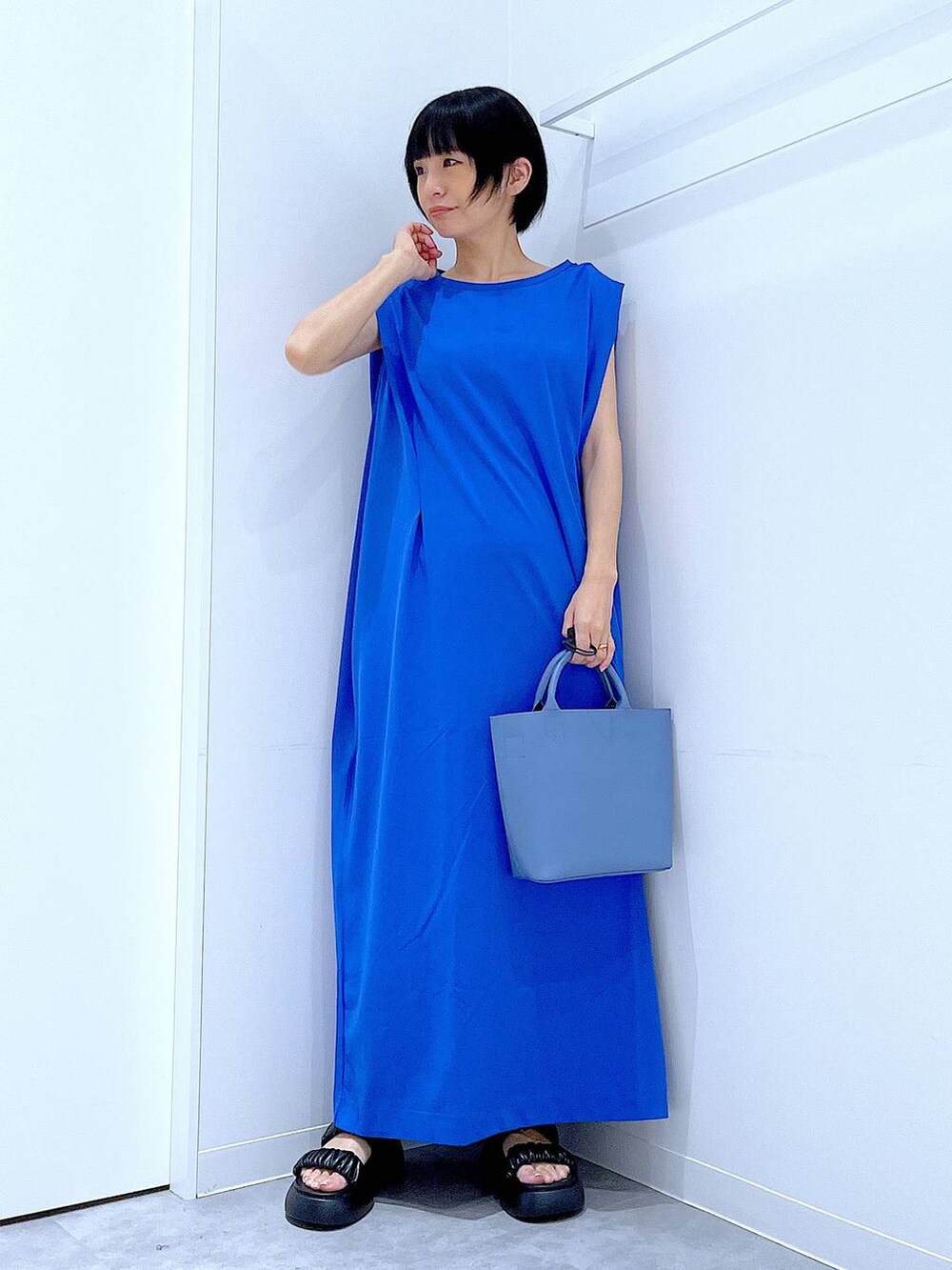 ブラック系のサンダル、ブルー系のワンピース、ブルー系のショルダーバッグを着用したレディースの夏コーディネートの2枚目の写真
