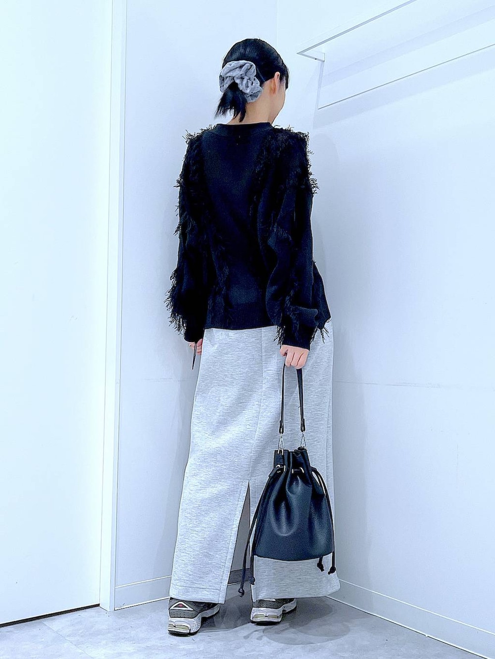 グレー系のスカート、ブラック系のショルダーバッグ、ブラック系のカーディガン/ボレロを着用したレディースの春コーディネートの5枚目の写真