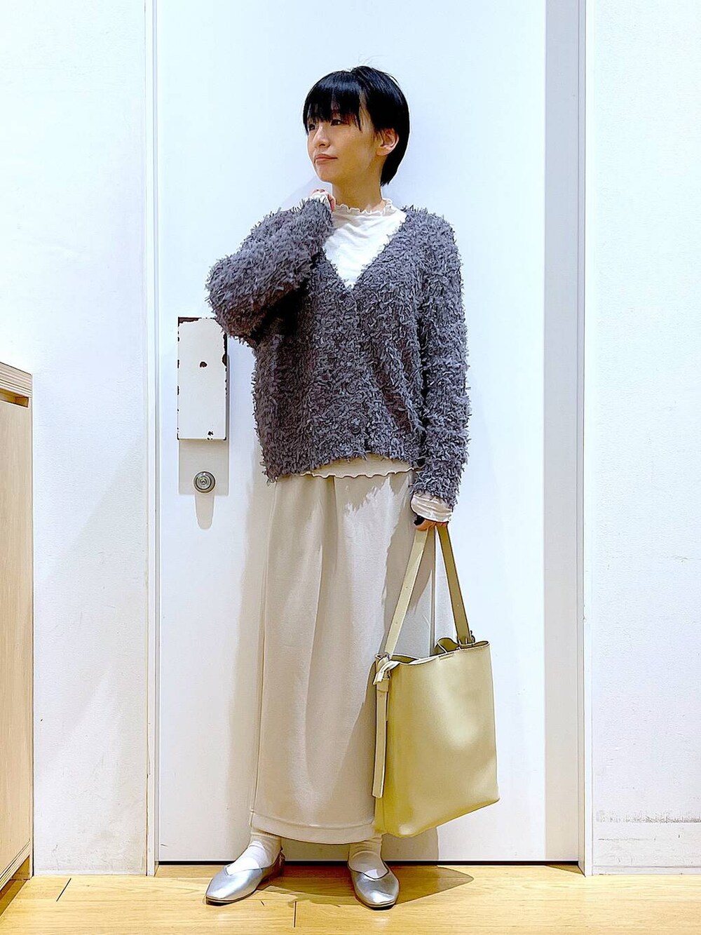 ベージュ系のTシャツ/カットソー、ホワイト系のショルダーバッグ、シルバー系のパンプスを着用したレディースの春コーディネートの2枚目の写真