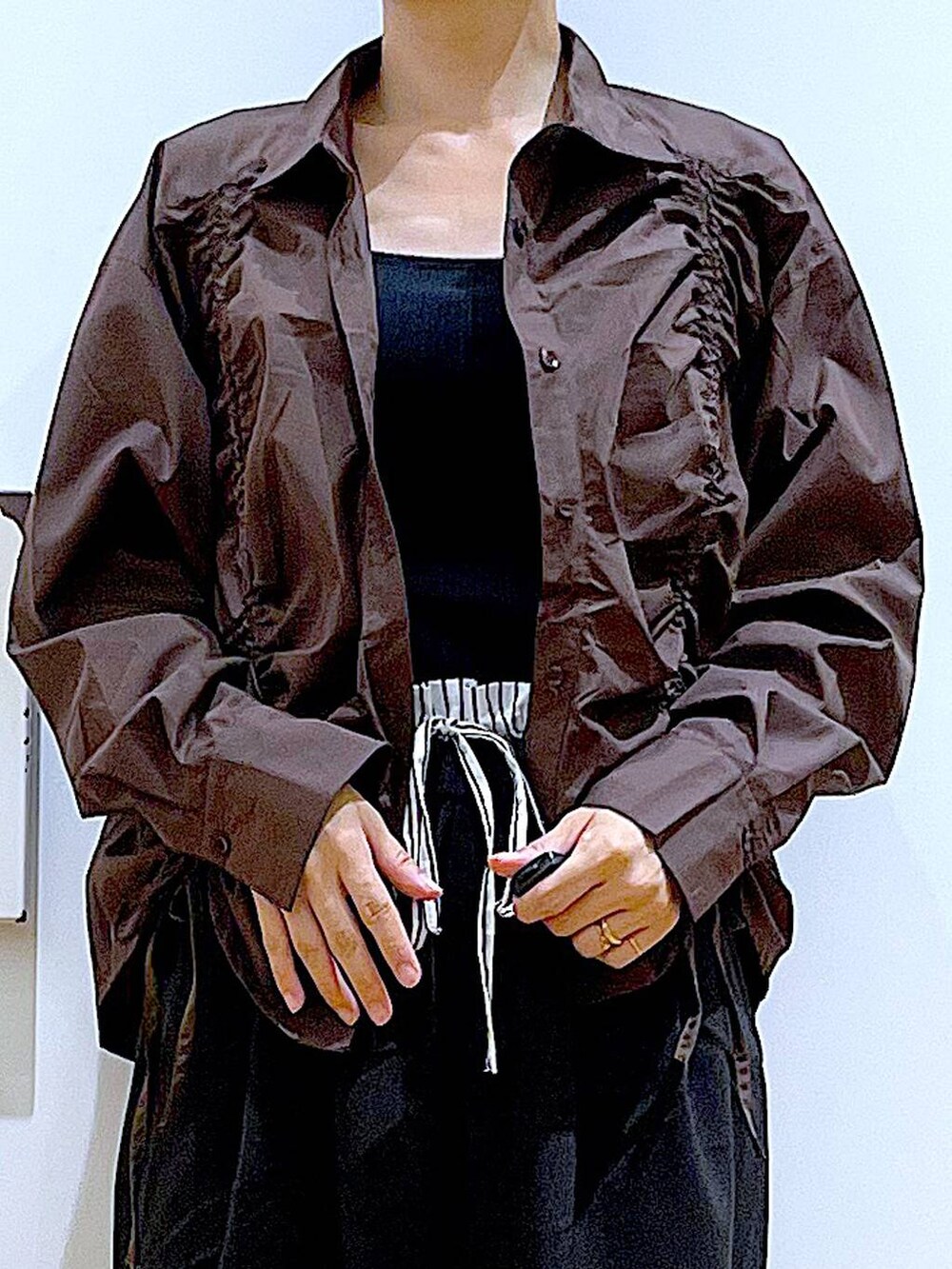 グレー系のショルダーバッグ、シルバー系のパンプス、ブラウン系のシャツ/ブラウスを着用したレディースの秋コーディネートの7枚目の写真