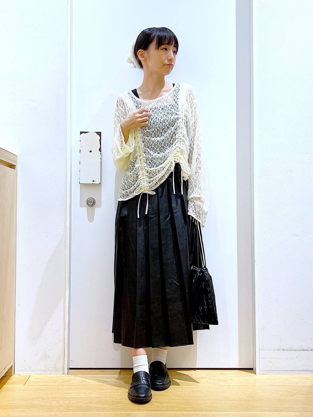 ブラック系のショルダーバッグ、ブラック系のローファー、ベージュ系のTシャツ/カットソーを着用したレディースの秋コーディネートの2枚目の写真