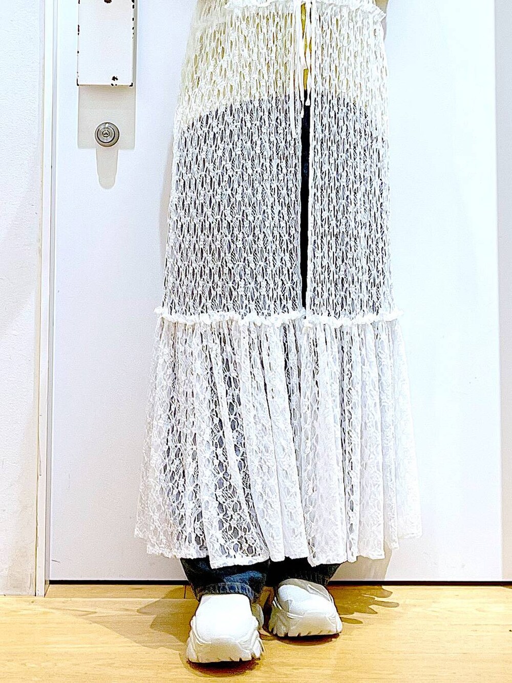 イエロー系のニット/セーター、グレー系のショルダーバッグ、ホワイト系のワンピースを着用したレディースの冬コーディネートの8枚目の写真