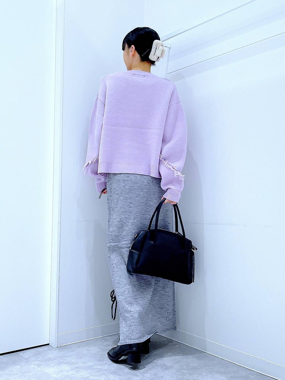 ブラック系のボストンバッグ、グレー系のスカート、ブラック系のブーツを着用したレディースの冬コーディネートの5枚目の写真