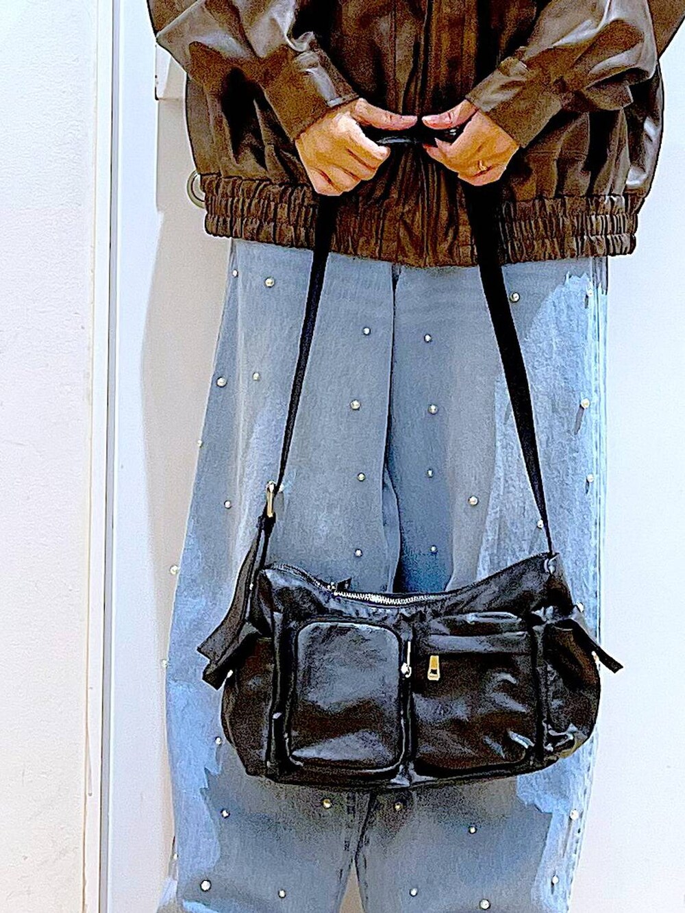 ブラウン系のブルゾン、ベージュ系のブーツ、ブルー系のデニムパンツを着用したレディースの秋コーディネートの9枚目の写真