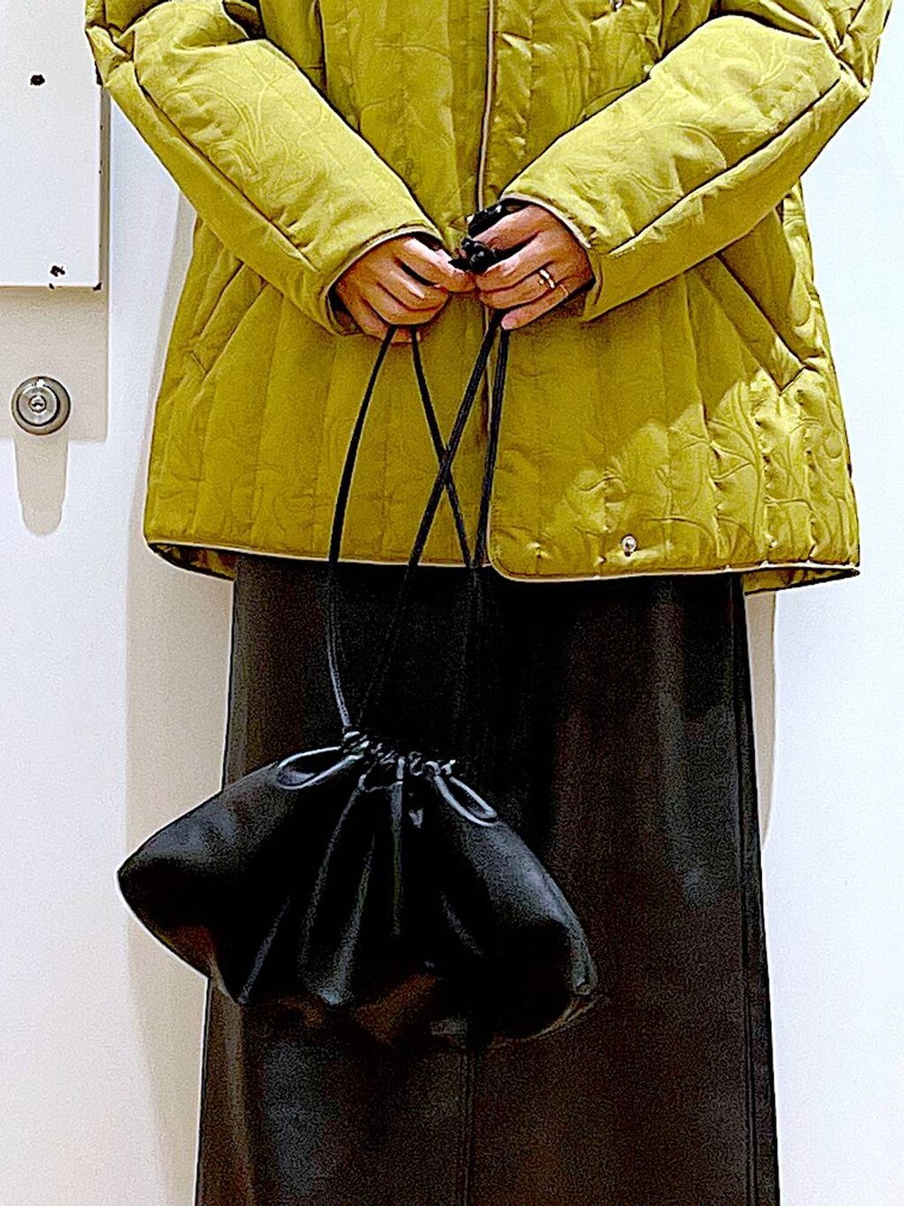 ブラック系のブーツ、ブラック系のショルダーバッグ、ブラック系のニット/セーターを着用したレディースの冬コーディネートの9枚目の写真