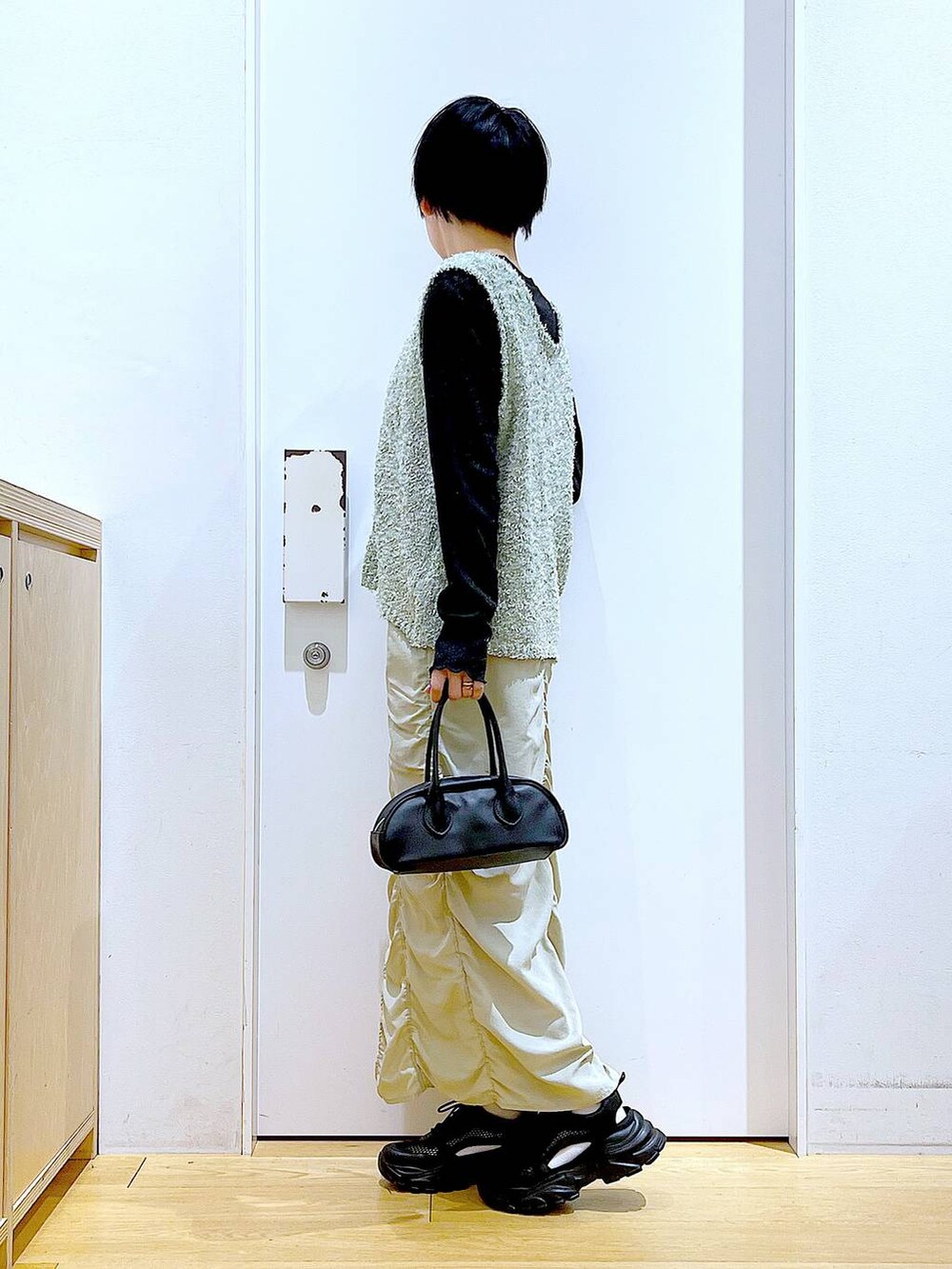 ベージュ系のスカート、ブラック系のボストンバッグ、ブラック系のTシャツ/カットソーを着用したレディースの春コーディネートの3枚目の写真