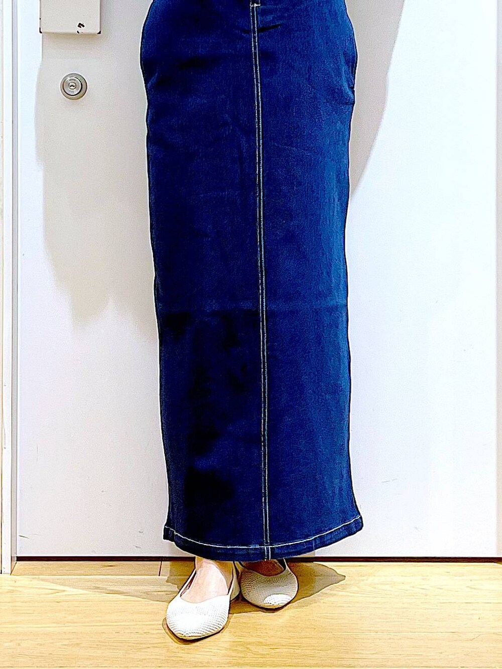 ホワイト系のパンプス、ブルー系のジャンパースカート、ブラック系のショルダーバッグを着用したレディースの夏コーディネートの8枚目の写真