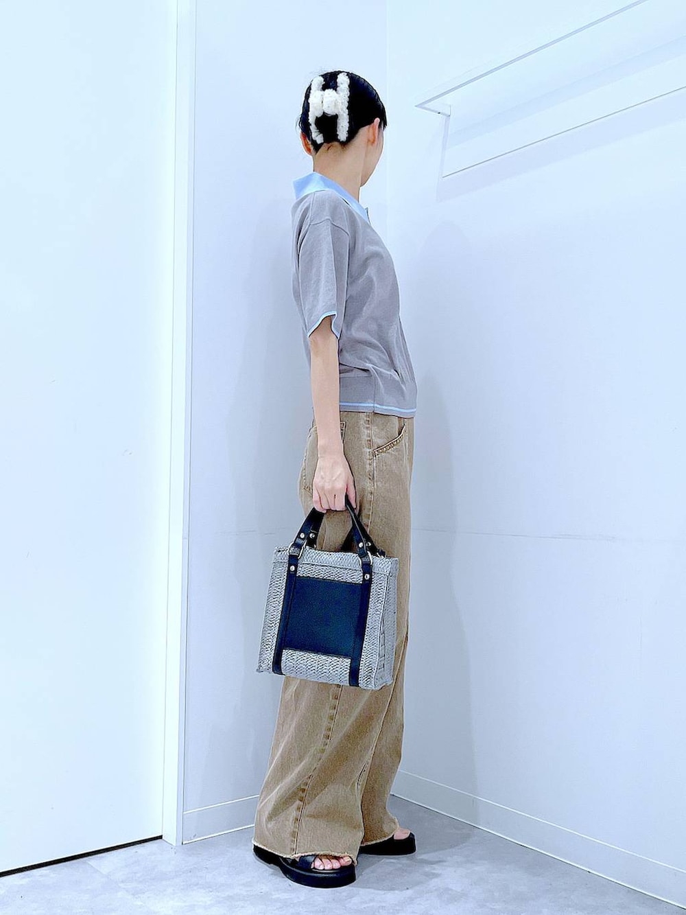 グレー系のショルダーバッグ、ブラック系のサンダル、ベージュ系のデニムパンツを着用したレディースの夏コーディネートの4枚目の写真